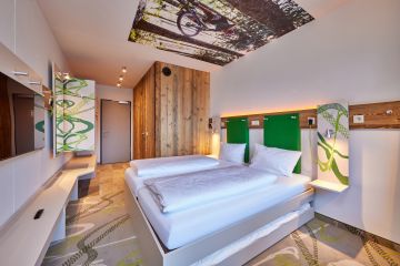Frisches Grün und warme Holztöne erwarten Dich neben vielen Ablagemöglichkeiten im Hotelzimmer in Farchant