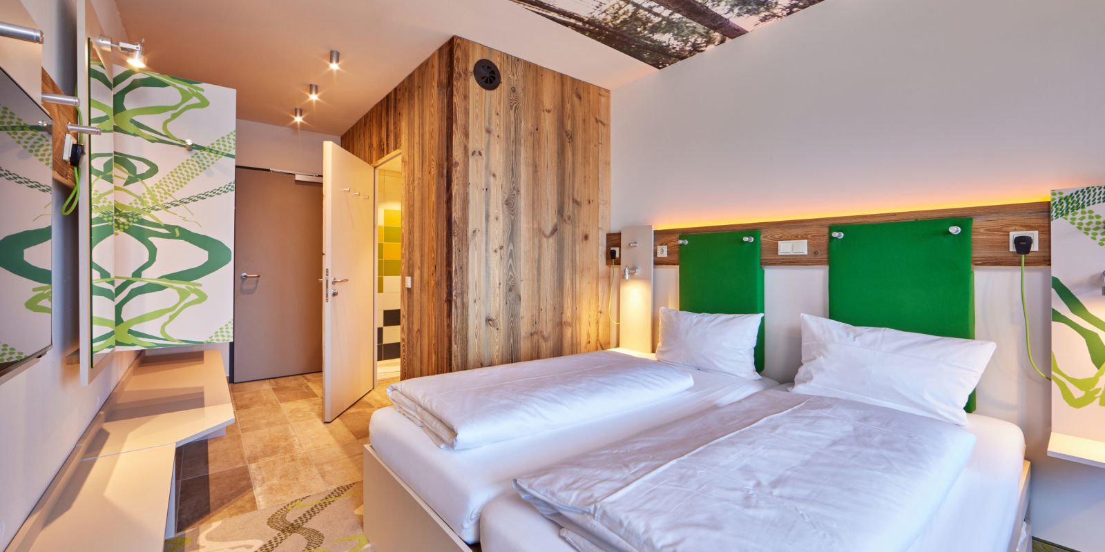 Ein helles und modernes Zimmer, mit Badezimmer und großer Dusche erwartet Dich im Explorer Hotel Garmisch.