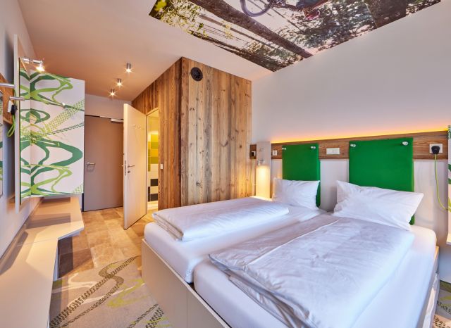 Ein helles und modernes Zimmer, mit Badezimmer und großer Dusche erwartet Dich im Explorer Hotel Garmisch.