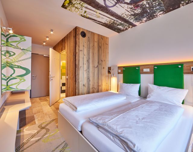 À l'hôtel Explorer Garmisch, une chambre lumineuse et moderne, avec salle de bains et grande douche, vous attend.