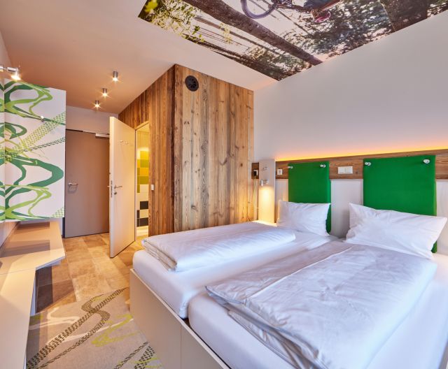 A bright and modern room with a bathroom and large shower awaits you at the Explorer Hotel Garmisch.