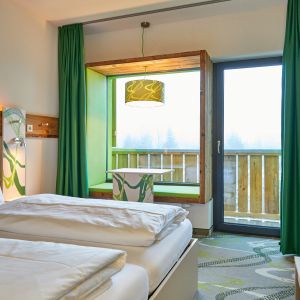 Ein Lieblingsplatz im Zimmer des Explorer Hotel Garmisch ist die Sitznische im Panoramafenster.