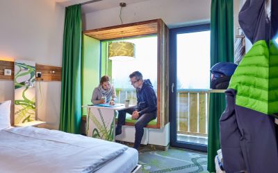 Tourenplanung machst Du im Explorer Hotel Garmisch ganz gemütlich in der Sitznische im Fenster.