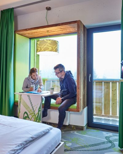 Tourenplanung machst Du im Explorer Hotel Garmisch ganz gemütlich in der Sitznische im Fenster.