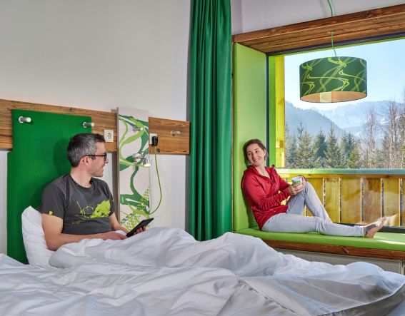 Tijd om heerlijk te ontspannen en te genieten van het uitzicht in uw gezellige hotelkamer in het Explorer Hotel Garmisch in Farchant. Of u nu heerlijk in bed ligt of met uw voeten omhoog op de bank bij het panoramaraam: vanuit uw kamer in het Explorer Hotel Garmisch heeft u altijd een fantastisch uitzicht op het landschap en de bergen.