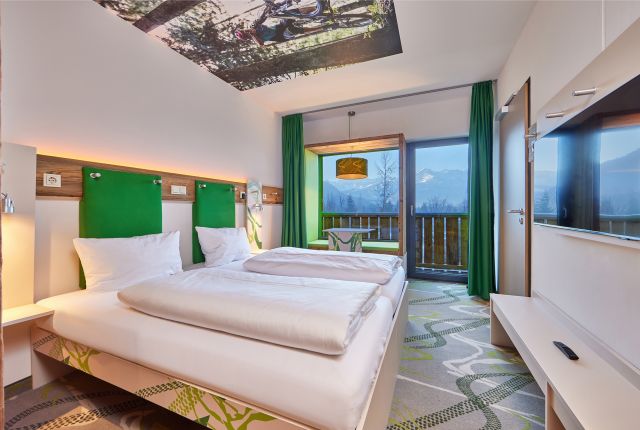 Das Explorer Hotel Garmisch in Farchant bietet moderne Zimmer in frischem Grün und mit toller Aussicht in die Berge.
