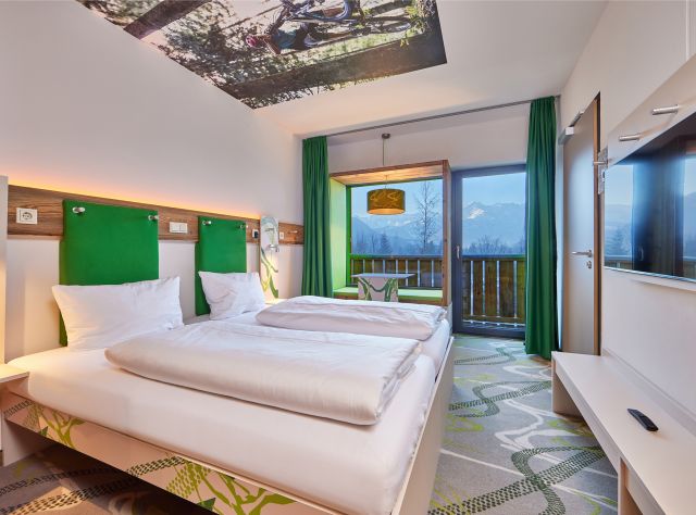 Das Explorer Hotel Garmisch in Farchant bietet moderne Zimmer in frischem Grün und mit toller Aussicht in die Berge.