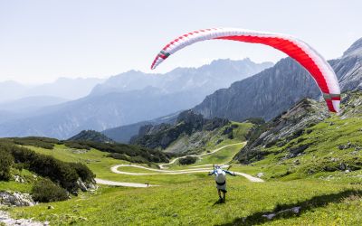 Sommer in Garmisch-Partenkirchen: Paraglider nutzen das schöne Wetter, um sich in waghalsige Lüfte zu stürzen! Abflug von der Alpspitze bei der Zugspitze.