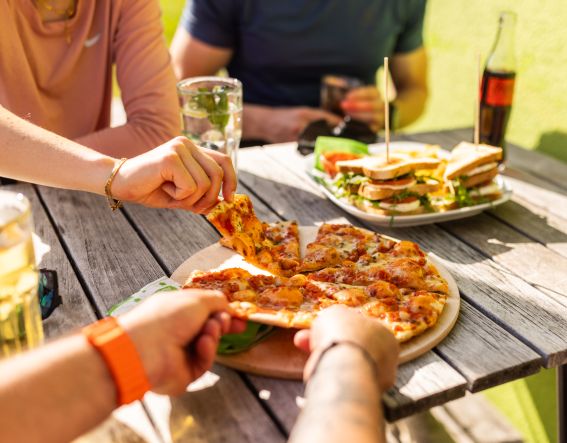 Pizza-time. Gemeinsames schlemmen auf der Terrasse vom Explorer Hotel Neuschwanstein. Viel Aktivität macht hungrig. Was wären die Explorer Hotels ohne die Lounge und die Bar? Als kommunikativer Mittelpunkt des Hotellebens findest Du hier alles, was Du für einen coolen Aktivurlaub brauchst.