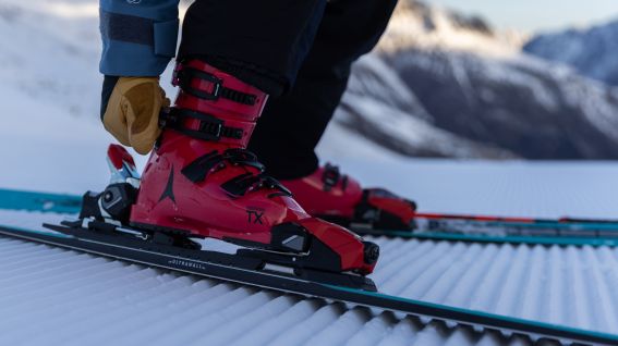 Primo piano con presa salda: scarponi da sci rossi su una pista appena battuta nel comprensorio sciistico di Gaislachkogel, nella valle dell'Ötztal.