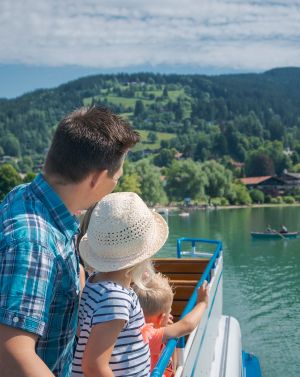 Eine Vater fährt mit seinen Kindern auf einem Schiff auf dem Schliersee Es ist möglich, mit einem Schiff über den Schliersee zu fahren.