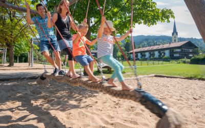 A family is having a lot of fun at a playground in Schliersee.