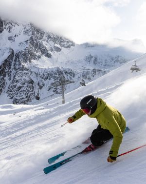 Un homme dévale les pistes de ski de Giggijoch sous le soleil et s'amuse beaucoup.