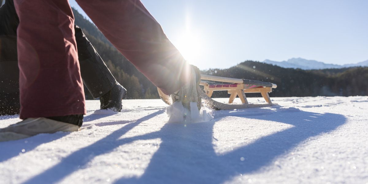 Detailaufnahme eines Holzschlittens im Schnee im Ötztal – winterlicher Familienausflug in Tirol