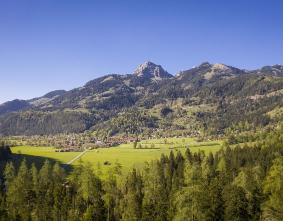 Der Blick aus der Ferne auf Bayrischzell an einem wunderschönen Tag mit strahlend blauem Himmel.