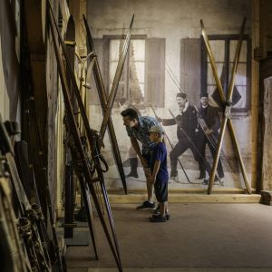 Familie schaut sich alte Skier in einem Museum an. Es ist das Markus Wasmeier Freilichtmuseum am Schliersee.