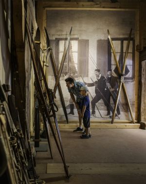 Una famiglia sta ammirando vecchi sci in un museo. Si tratta del Museo all'aperto Markus Wasmeier a Schliersee.