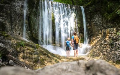 Ein Pärchen schaut sich einen Wasserfall an.
