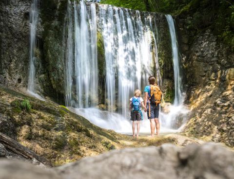 Ein Pärchen schaut sich einen Wasserfall an.
