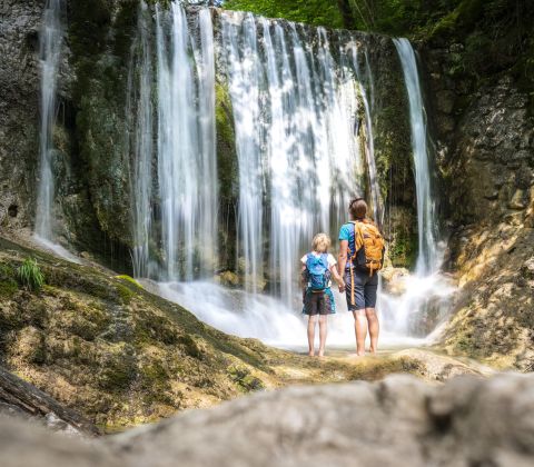 Un couple contemple une cascade.