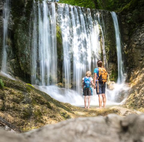 Een stel kijkt naar een waterval.