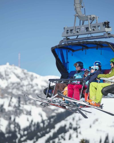 Skiers take a gondola up the mountain.