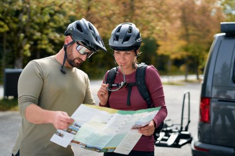 Fahrradfahrer studieren die Karte um den richtigen Weg zu finden.