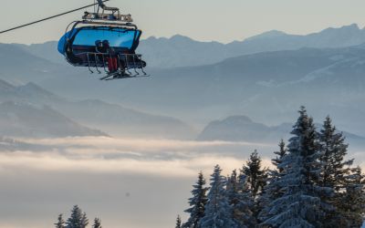Skifahrer sitzen im 8er-Sessellift im Skigebiet Sudelfeld