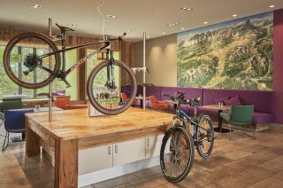 Fahrräder an der Bike-Werkstatt im Explorer Hotel Fahrräder auf Montageständern in der offenen Bike-Werkstatt des Hotels.