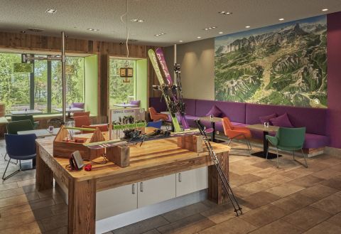 Open lobby with central workbench, comfortable seating and sporty-modern design.