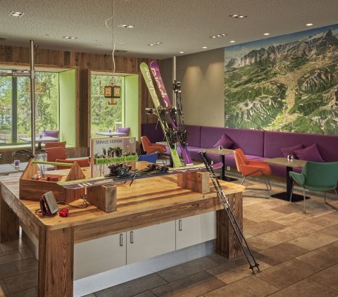 Open lobby met centrale werkbank, comfortabele zitgelegenheid en een sportief-modern design.