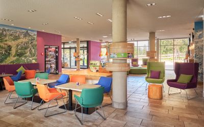 Helle Lounge mit farbenfrohen Sesseln, Sitzgruppen und einem unkomplizierten, offenen Raumkonzept.