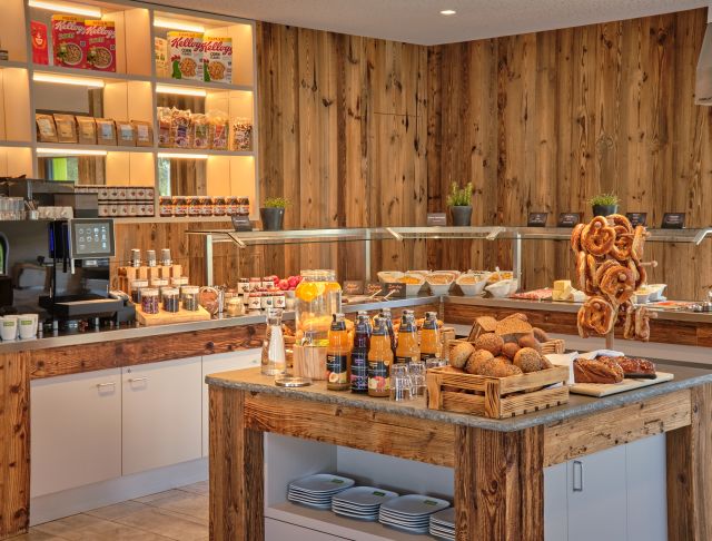 Buffetbereich mit verschiedenen Brotsorten, Cerealien und weiteren Frühstückszutaten.