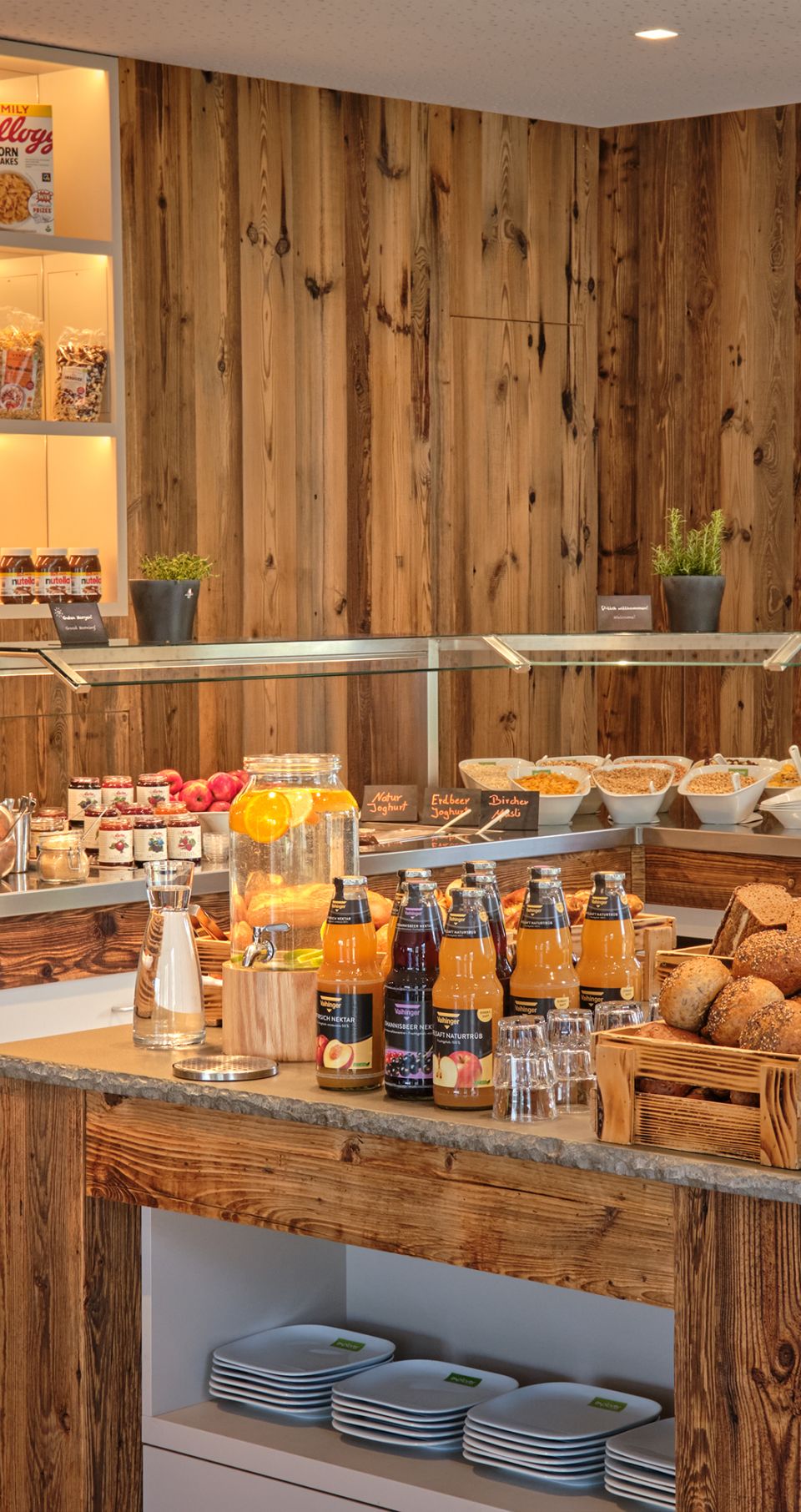 Buffetbereich mit verschiedenen Brotsorten, Cerealien und weiteren Frühstückszutaten.
