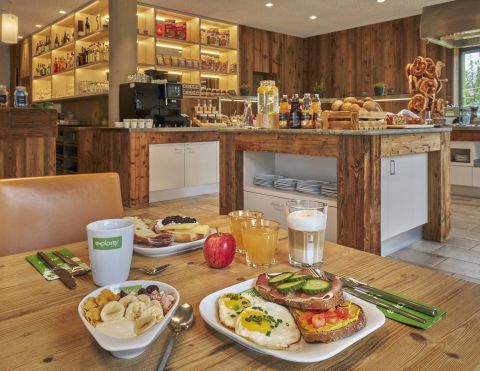 Een ontbijttafel gedekt voor het buffet met muesli, vers fruit, koffie en vruchtensappen.