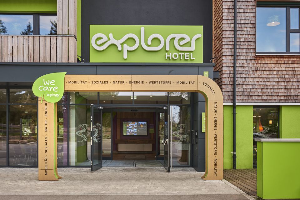 Frontaler Blick auf den markanten, grün gestalteten Eingang eines Hotels der Explorer Hotels.