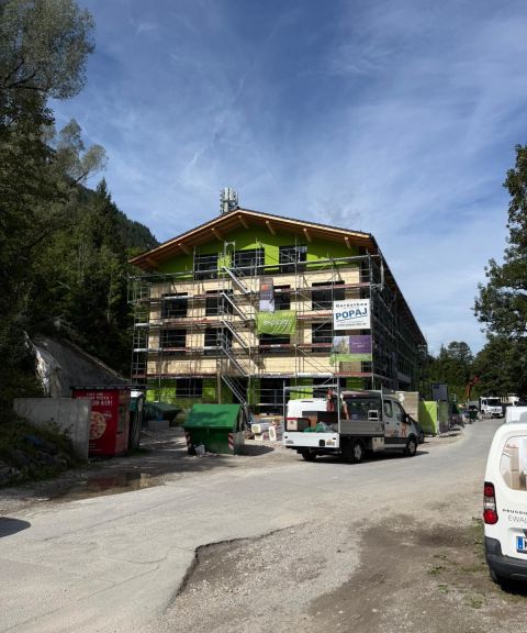 Baustelle Explorer Hotel Bayrischzell Das Gebäude wird renoviert. Bauarbeiten finden an einem Ort in den Bergen statt. Die Fassade wird erneuert und Gerüste stehen.