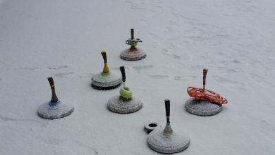 Sechs Eisstöcke stehen nebeneinander auf dem Eis Sechs Eisstöcke stehen auf einer Eisfläche bereit zum Eisstockschießen.