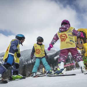 Drei Kinder beim Skifahren am Tannerfeld in Bayrischzell Drei Kinder üben das Skifahren am Tannerfeld in Bayrischzell vor winterlicher Bergkulisse