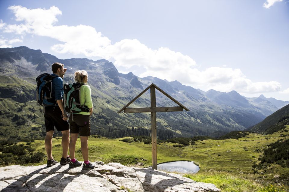 Bleibe am kleinen Gipfelkreuz stehen und schaue auf den geschafften Weg zurück. Rund um Gaschurn im Montafon in Vorarlberg gibt es tolle Wanderungen zu entdecken.
