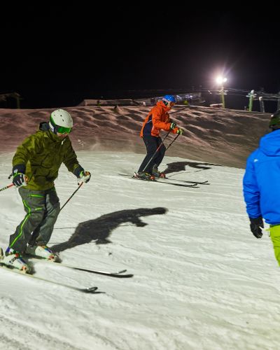 Snowboarder und Skifahrer unterwegs auf den Allgäuer Skipiste. Im Wintersportort Nesselwang ist die Schneehöhe perfekt. Sieh selbst, in Deinem Urlaub im Winter im Explorer Hotel Neuschwanstein.