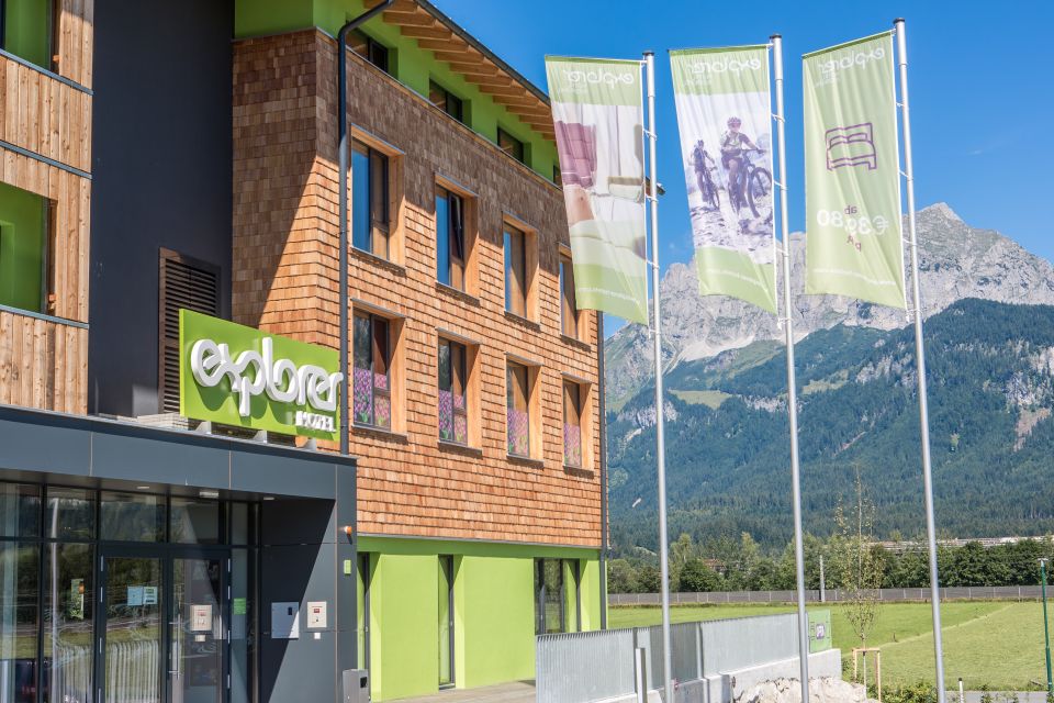 Hinter den Fahnen des Explorer Hotel Kitzbühels versteckt sich ein grandioser Blick auf die den Wilden Kaiser.