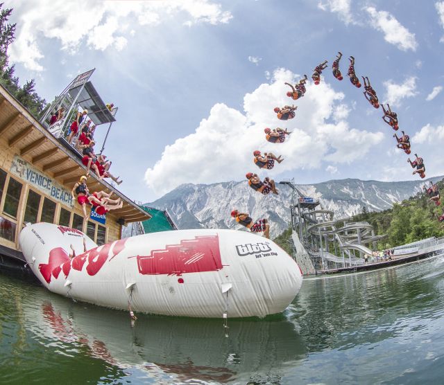 At AREA 47 in the Ötztal Valley, you can be catapulted through the air on a gigantic air cushion. The Blobber sits on one end of the air cushion, while the Jumper jumps onto the other end. The Blobber is catapulted through the air and lands in the water.