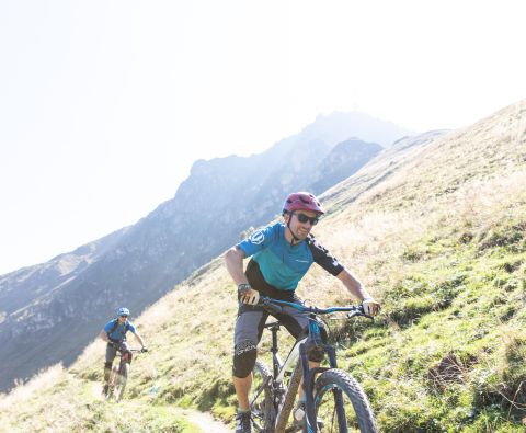 Letnie wakacje rowerowe z rodziną w Alpach Kitzbühelskich w Austrii. Jazda na rowerze górskim lub elektrycznym wokół hotelu Explorer w St. Johann in Tirol.