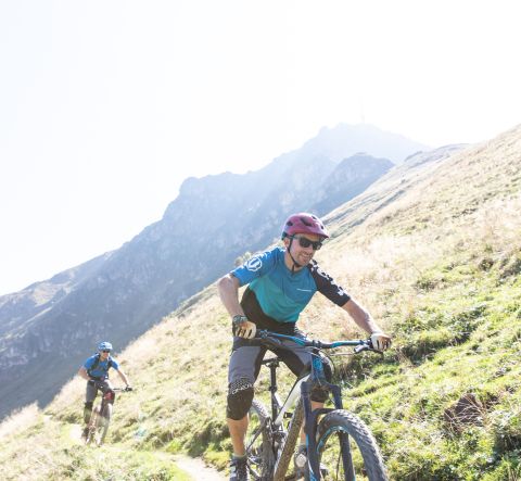 Kerékpározás családi nyári vakáción a Kitzbüheli-Alpokban, Ausztriában. Hegyi kerékpározás vagy elektromos kerékpározás az Explorer Hotel környékén, St. Johann in Tirolban.
