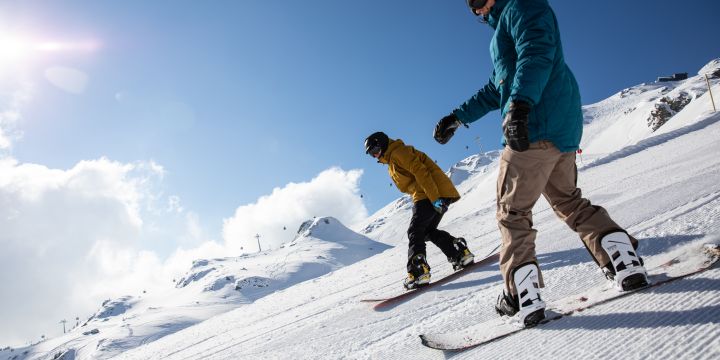 Snowboarden bei strahlendem Sonnenschein im Winterurlaub im Explorer Hotel