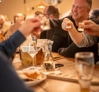 Eine Gruppe mit Freunden trinkt zusammen einen Schnaps.