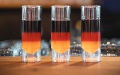 Drei Schnapsgläser mit Deutschlandflagge darauf stehen auf der Bar