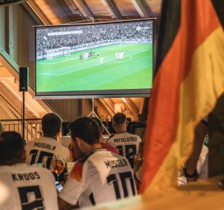 Übertragung des Deutschland-Spiels auf der Leinwand inder Faßhalle. Die deutschen Fußballfans schauen gebannt zu.