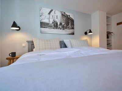 Auch das zweite Schlafzimmer der Ferienwohnung ist großzügig und modern eingerichtet. Mit einem Doppelbett sowie einer Couch.